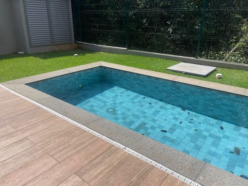 O deck da piscina com o mobiliário de lazer, como poltronas ou daybeds.
