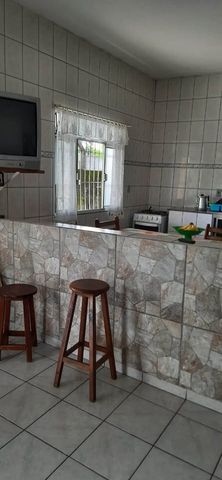 Cozinha integrada com ilha central e bancada de granito, oferecendo um espaço moderno e funcional para preparar suas refeições enquanto interage com a sala.