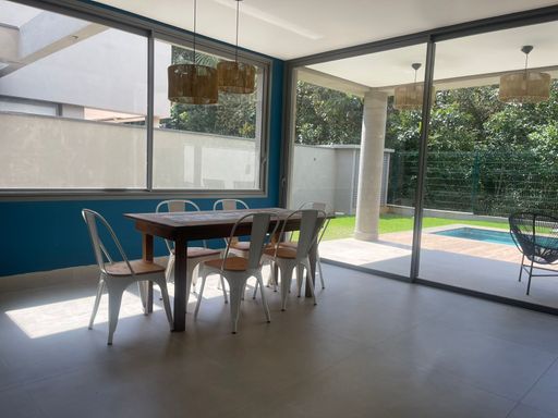 A sala de estar banhada pela luz natural que entra pelas janelas amplas.