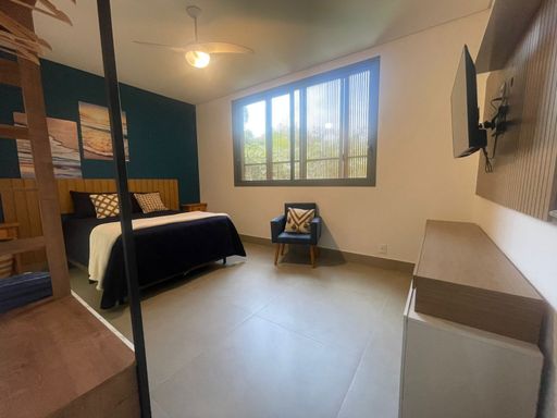 Uma das suítes com cama de casal e janela com vista.