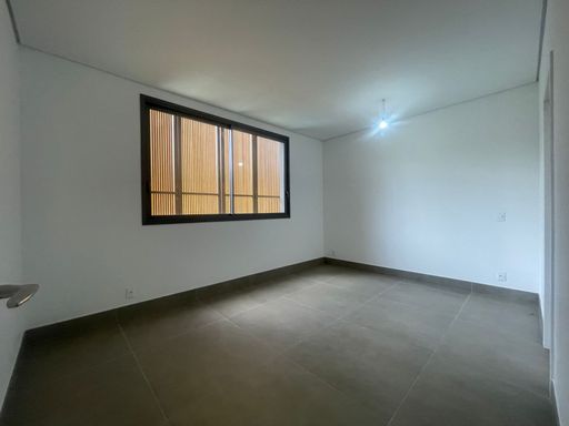 Um dos quartos, vazio, mostrando o potencial para se tornar uma suíte de hóspedes ou um espaço de lazer.